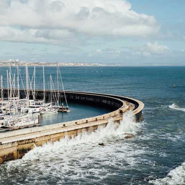 Protective sea wall sheltering multiple boats at harbor