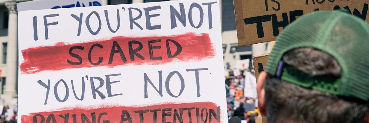 protester holding signs outside government building