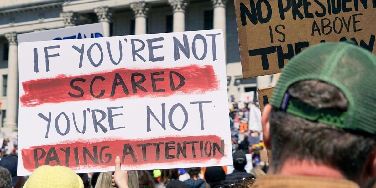 protester holding signs outside government building