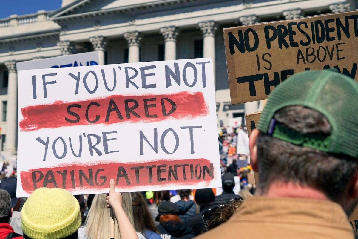 protester holding signs outside government building