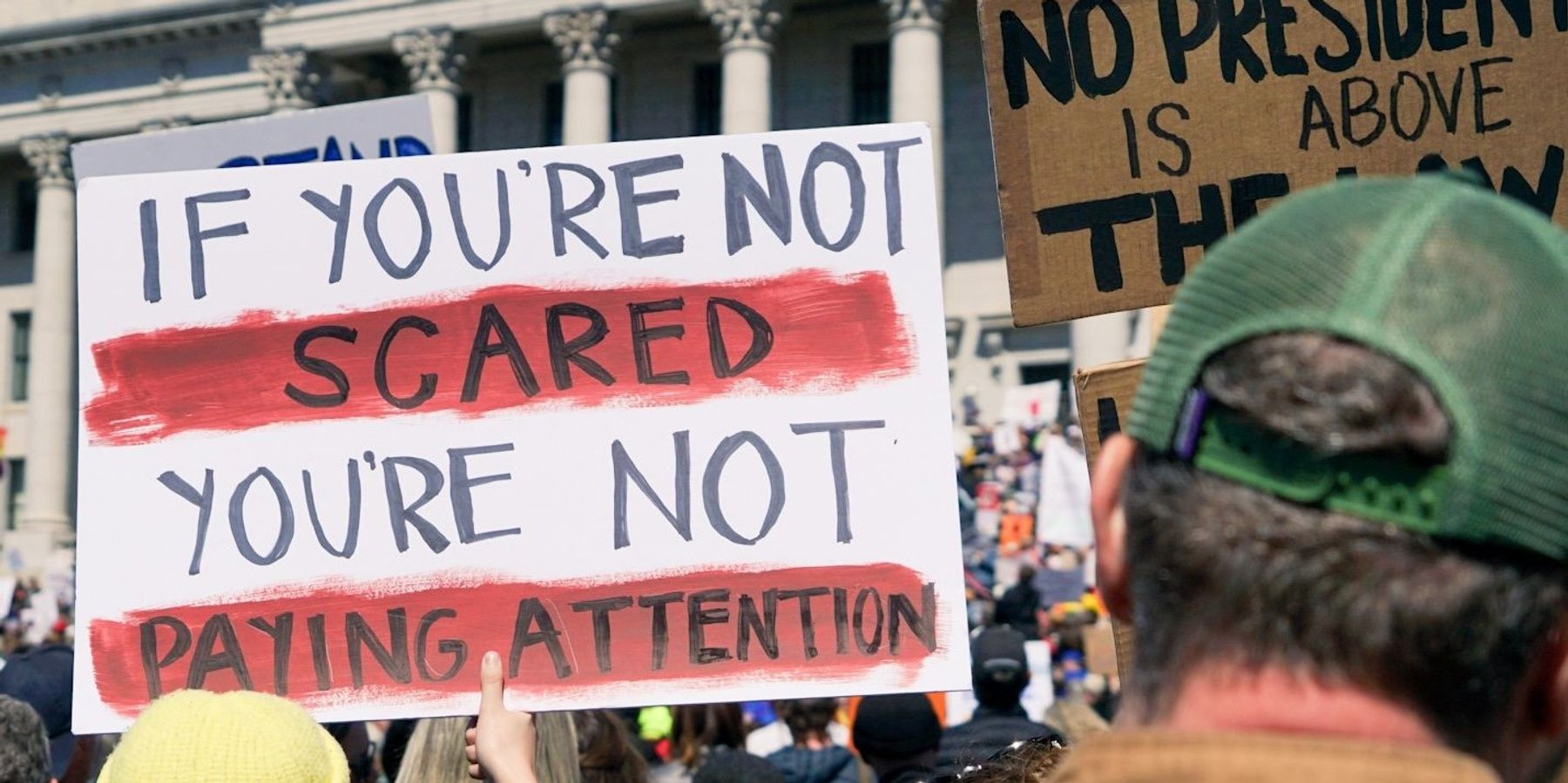protester holding signs outside government building