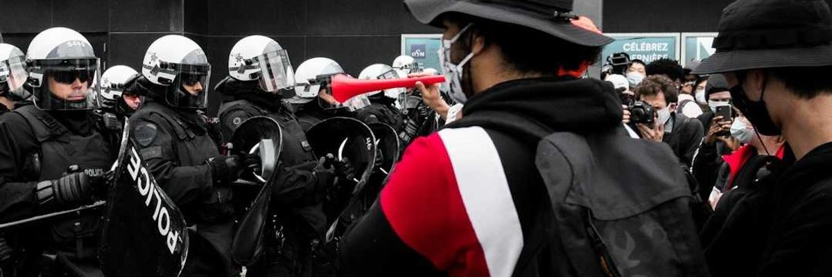 Protesters face of with police on city street