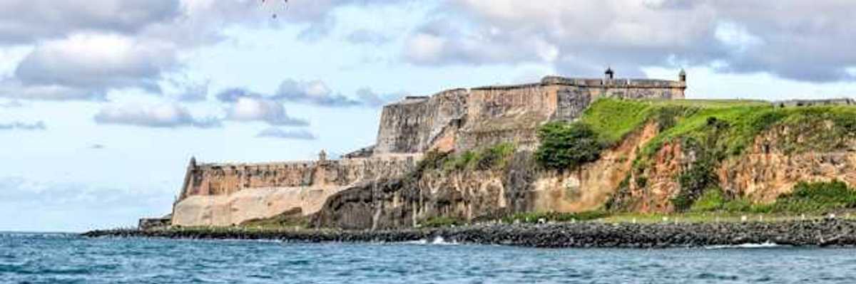 Puerto Rico's coastline with buildings that are ruins in the distance