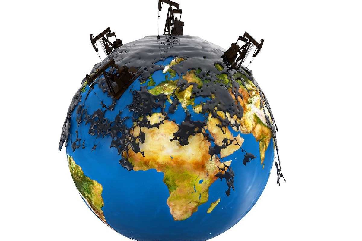 Pump jacks and oil spill over planet earth isolated on white background.