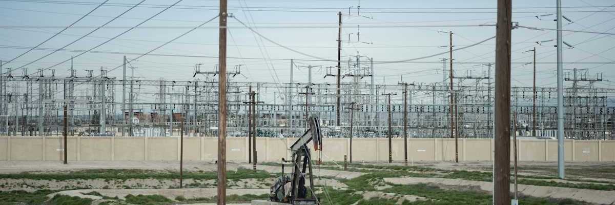 Pumpjack adjacent to electrical transmission facility