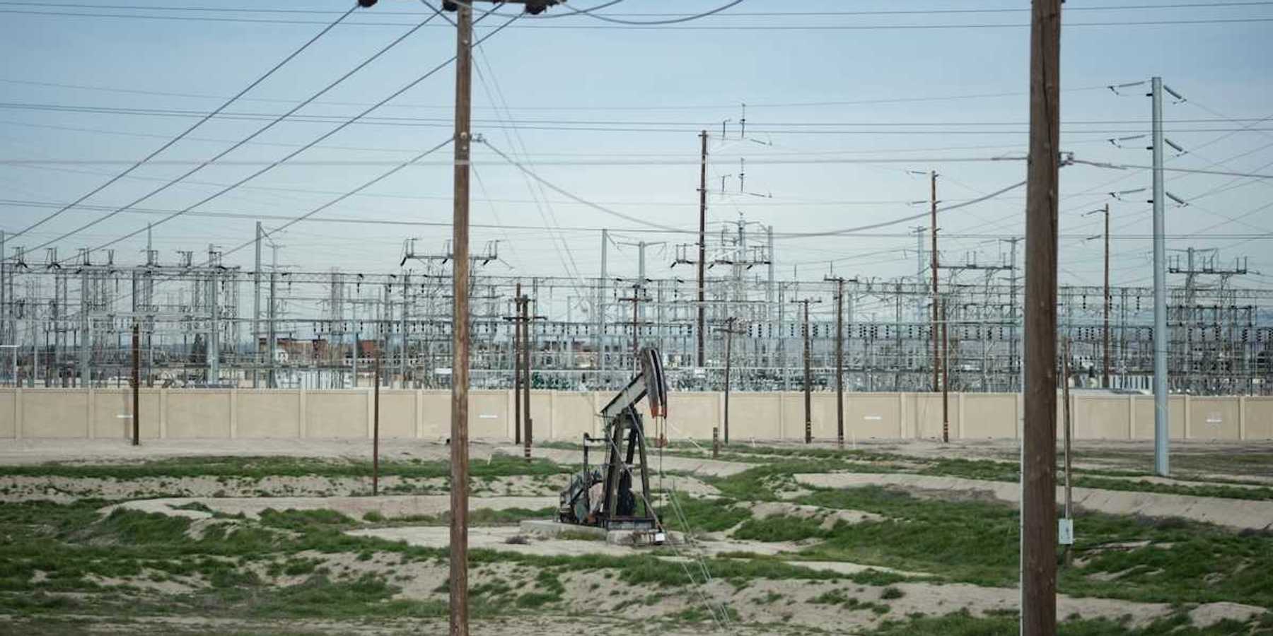 Pumpjack adjacent to electrical transmission facility