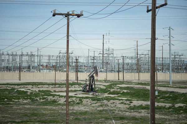 Pumpjack adjacent to electrical transmission facility