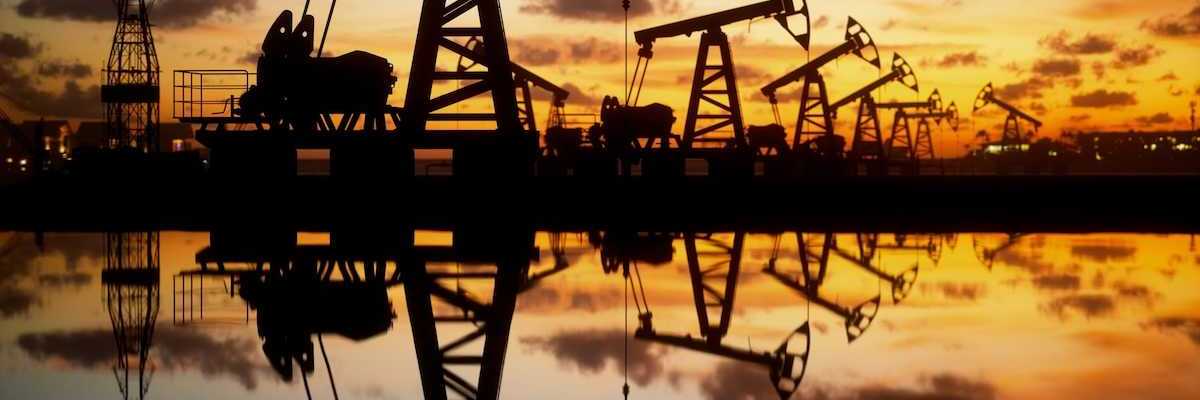 pumpjacks silhouetted against a setting (or rising) sun