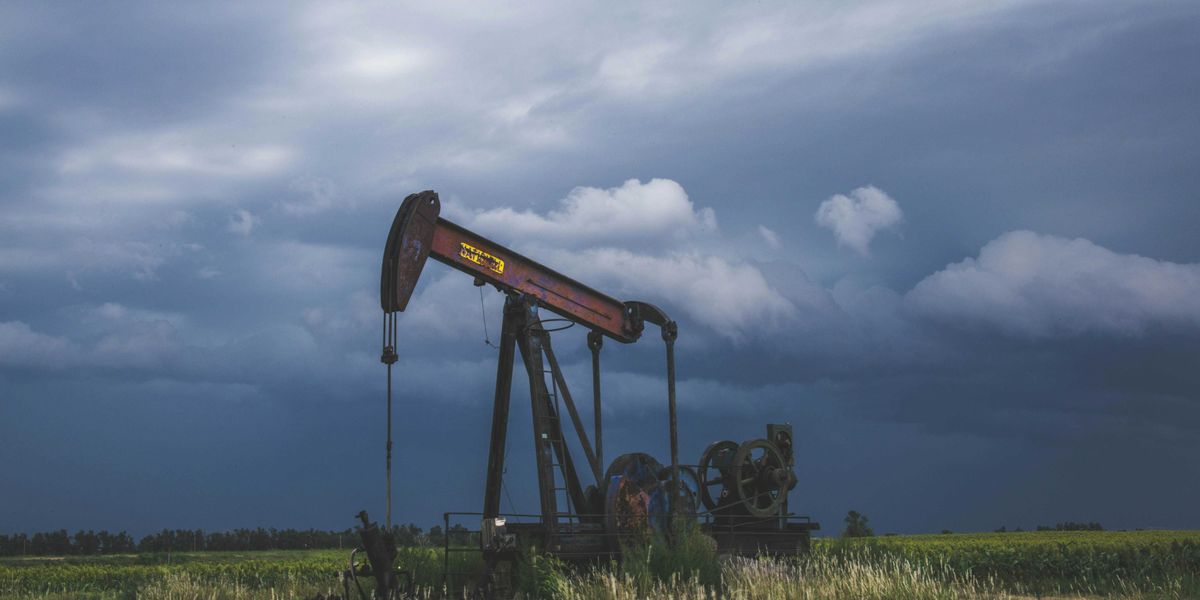 red and black heavy equipment on green grass field under white clouds during daytime