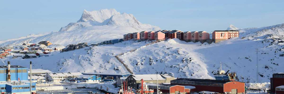 red and white ship on sea near snow covered mountain during daytime