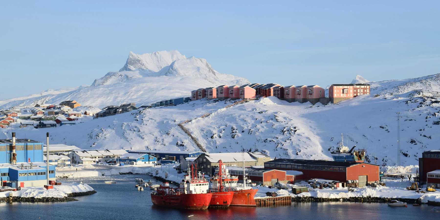 red and white ship on sea near snow covered mountain during daytime