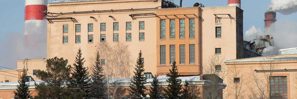 Red and white striped power plant smokestacks with billowing smoke emitting from the top