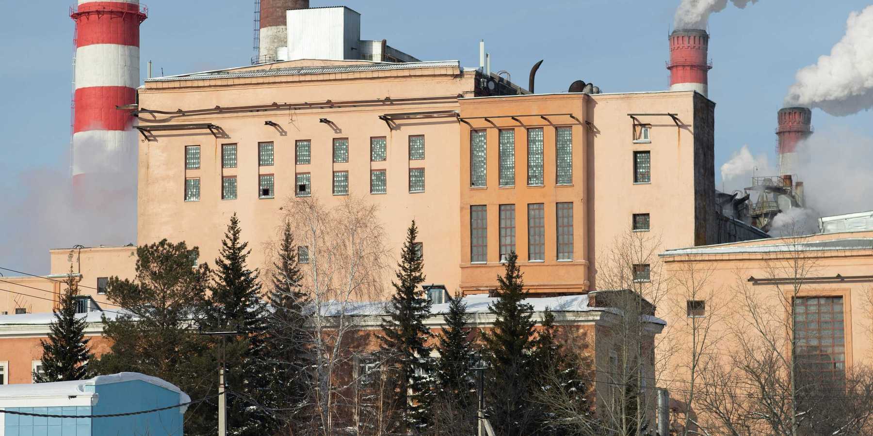 Red and white striped power plant smokestacks with billowing smoke emitting from the top