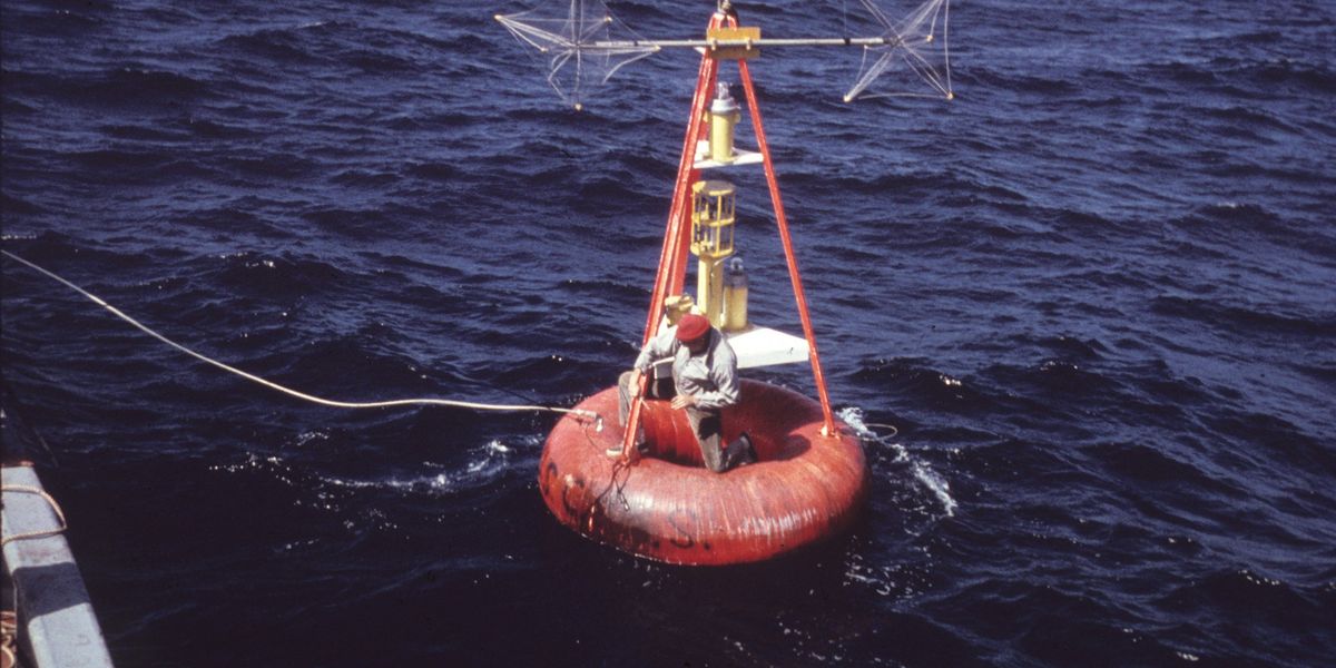 Red buoy being set up with scientific measurement equipment.