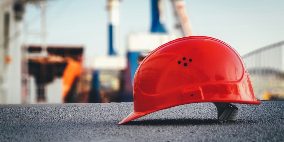 red hard hat on pavement\