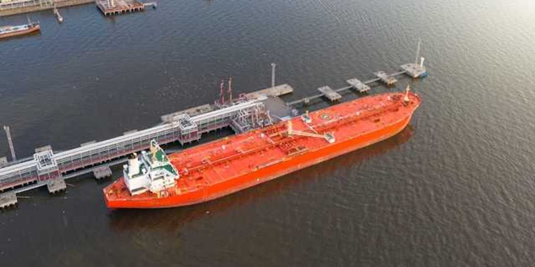 Red oil tanker at a dock
