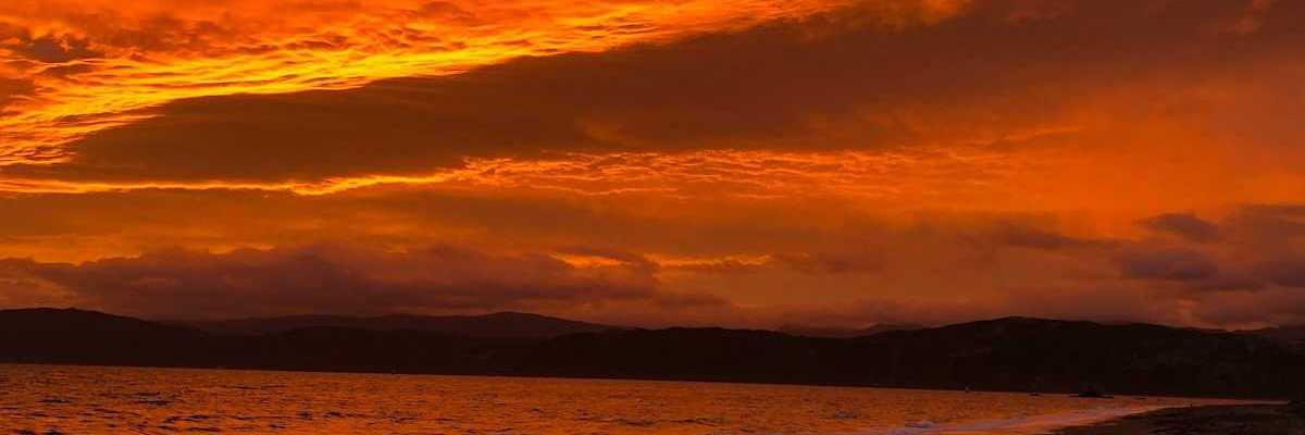 Red sky reflected in a pink-tinged ocean