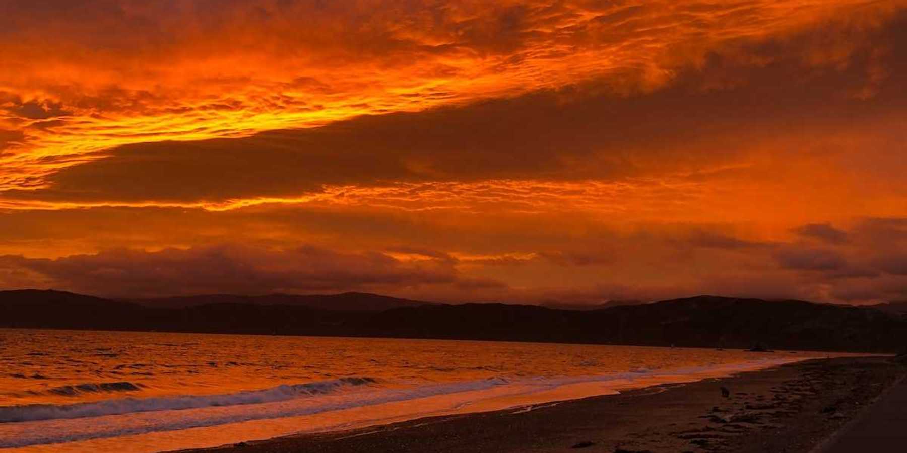 Red sky reflected in a pink-tinged ocean