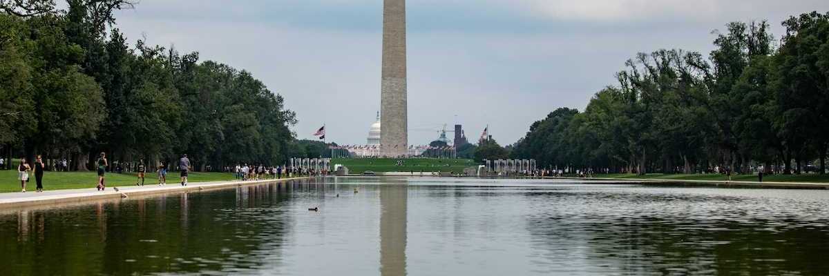 Reflecting pool on national mall with Washington monument and Capitol building behind