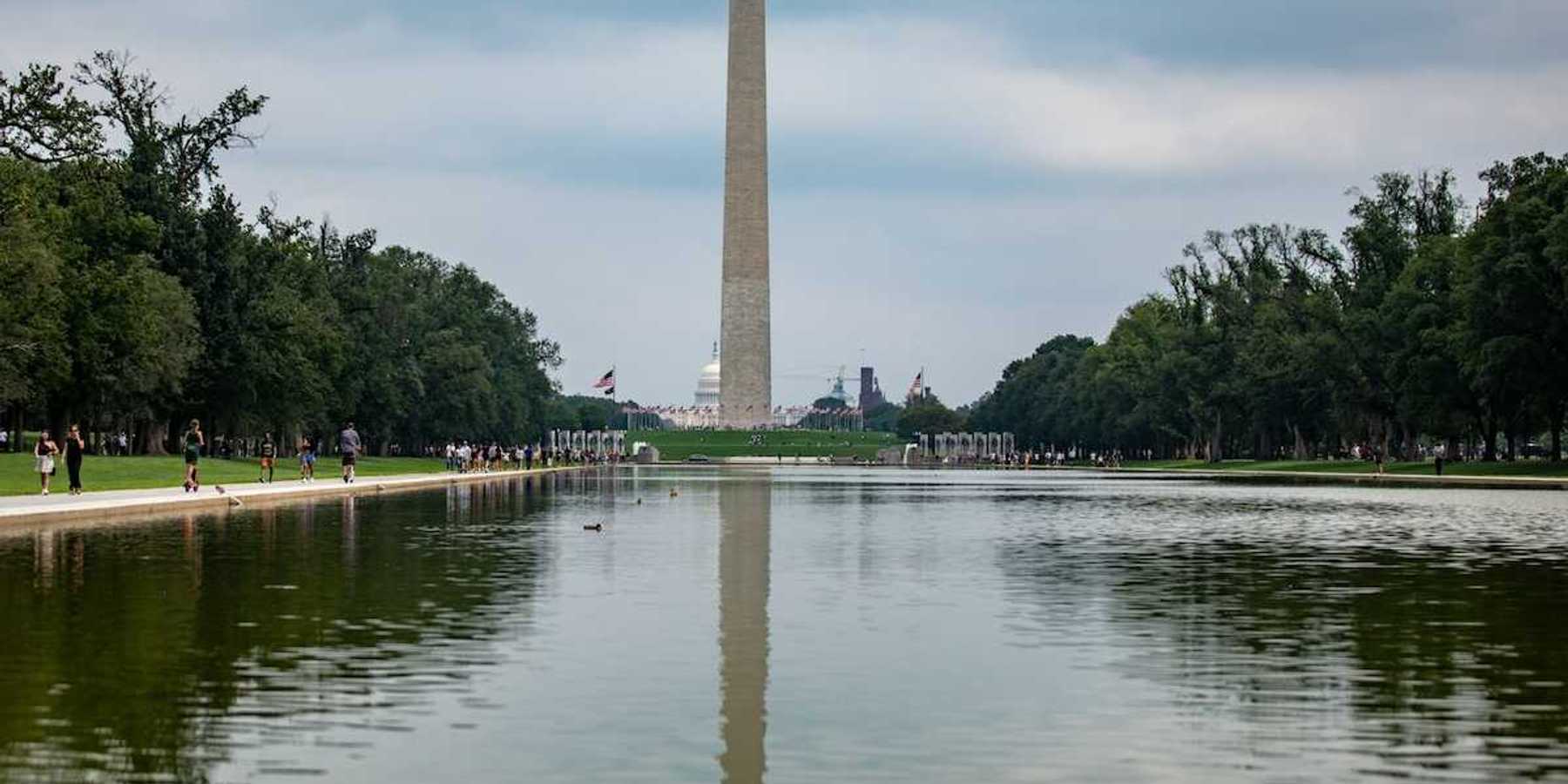 Reflecting pool on national mall with Washington monument and Capitol building behind