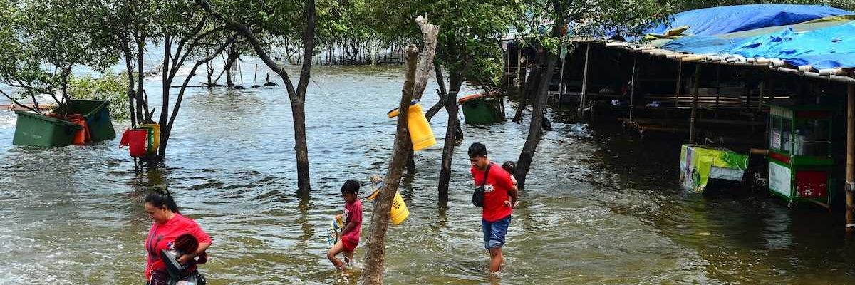 Refugees wading through floodwaters
