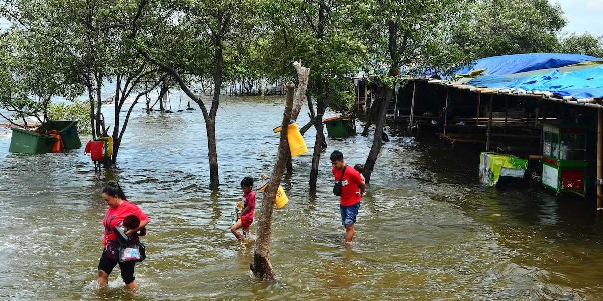 Refugees wading through floodwaters