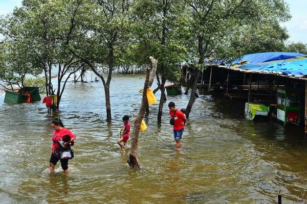Refugees wading through floodwaters
