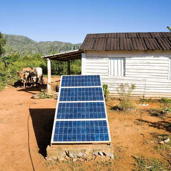 Renewable energy in the Cuban countryside with small white domicile and an oxcart