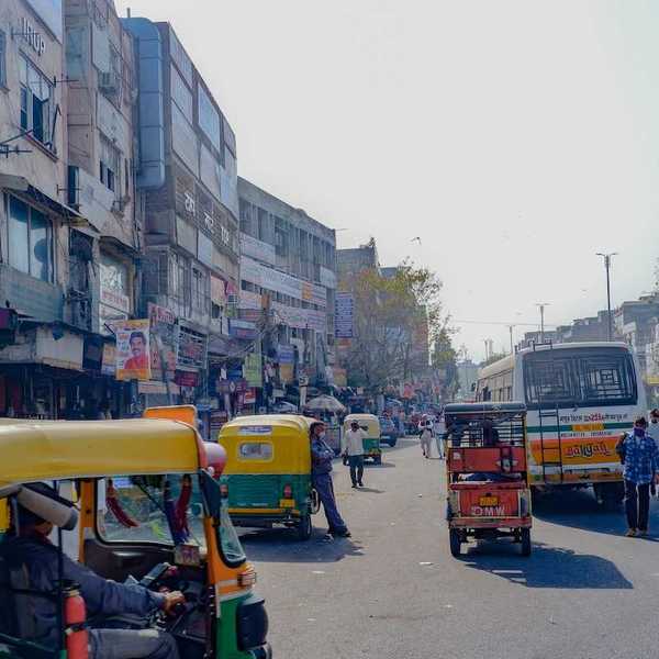 Rickshaws, scooters, busses, and pedestrians on a Delhi street