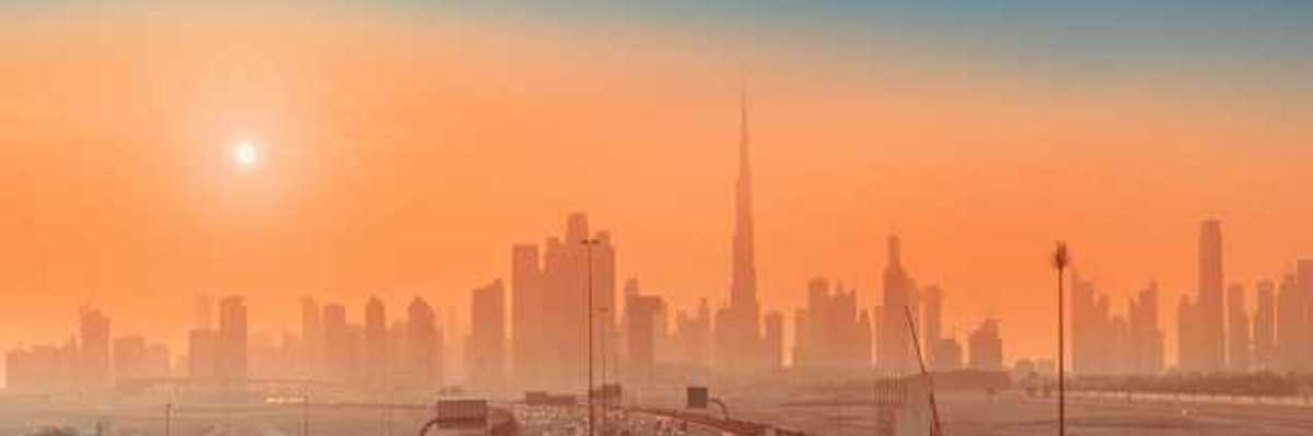 Roads in the forefront and a cityscape behind at sunrise