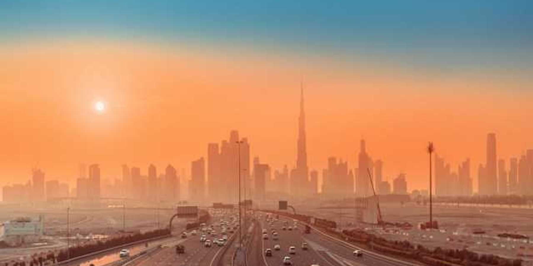 Roads in the forefront and a cityscape behind at sunrise