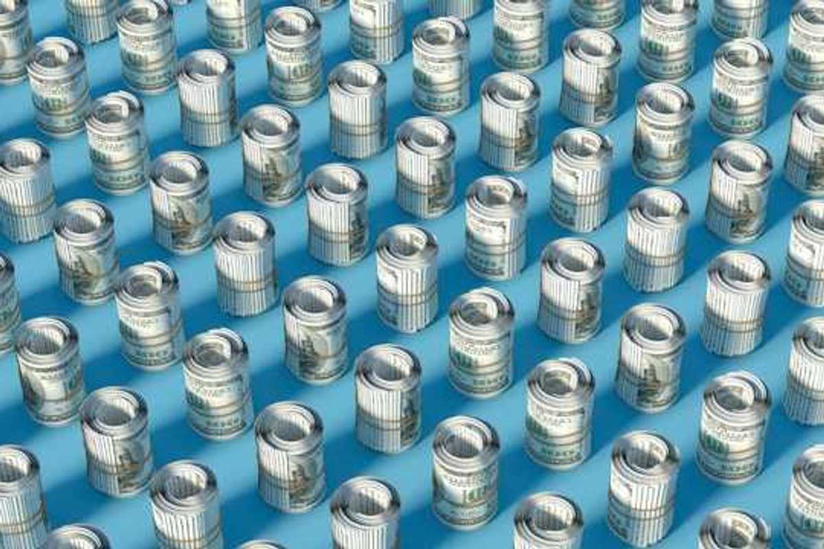 Rows of rolled up hundred-dollar U.S. bills on a blue surface