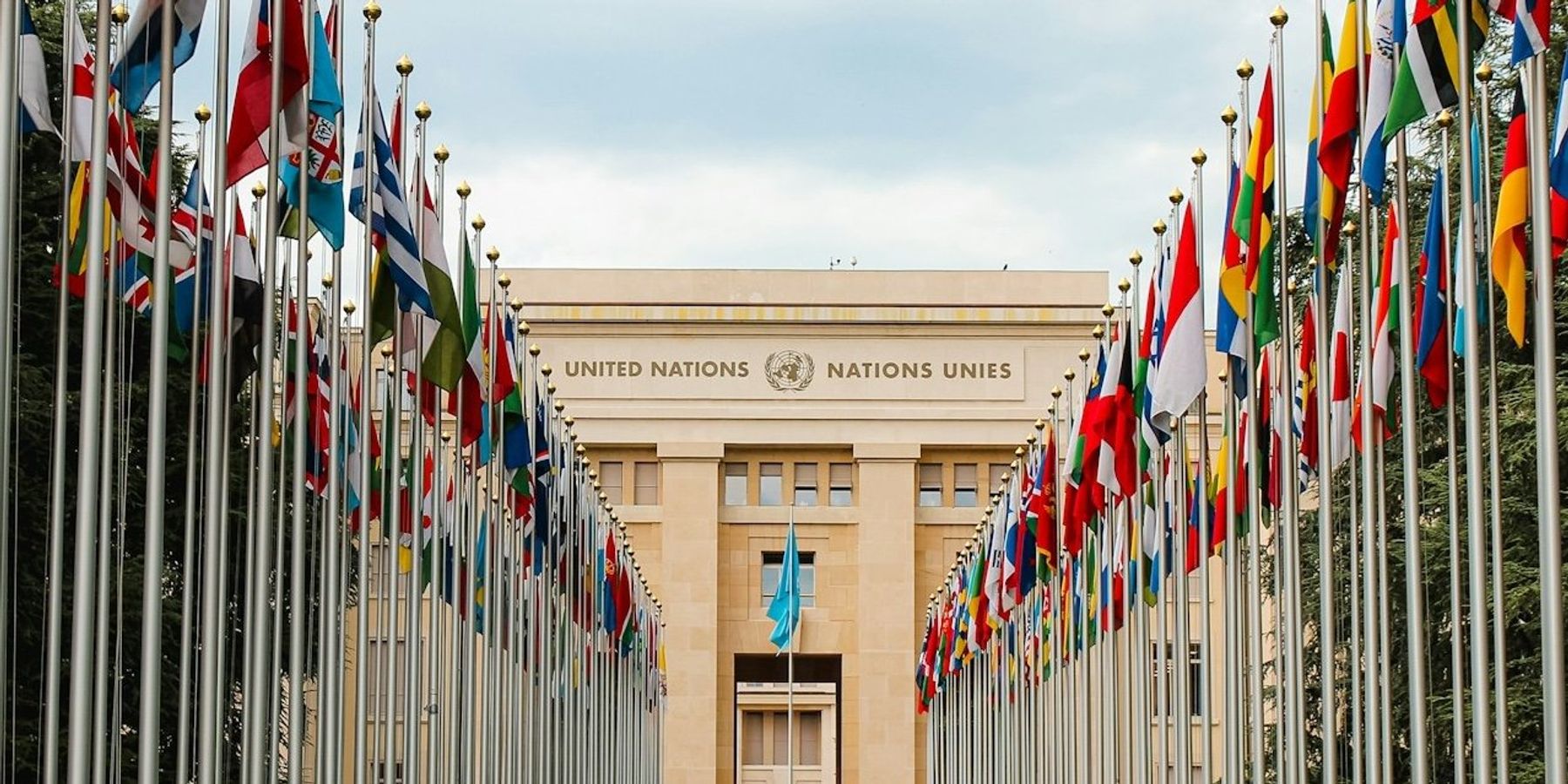 Rows of United Nations world flags outside UN building in Geneva, Switzerland.