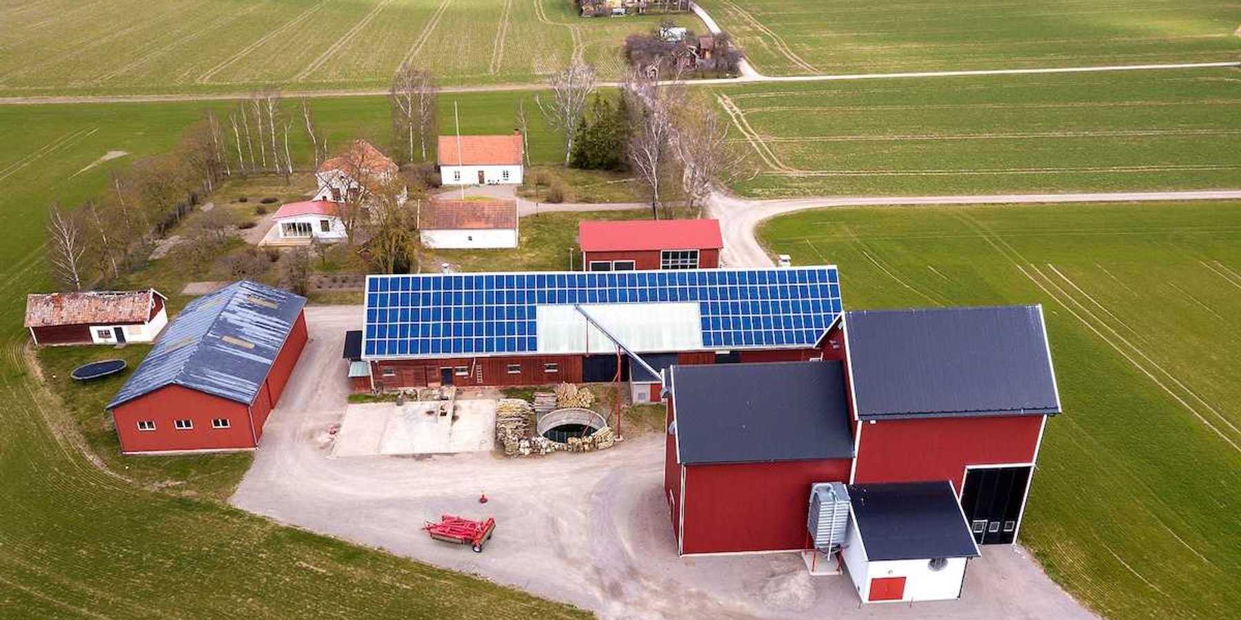 Rural landscape showing farm with solar photo voltaic panels system on a barn roof.