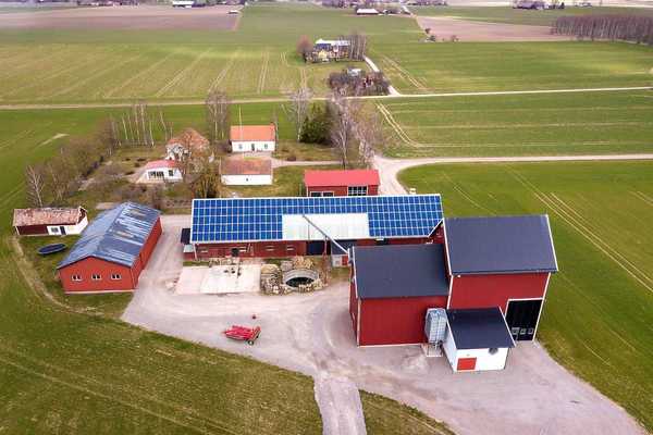 Rural landscape showing farm with solar photo voltaic panels system on a barn roof.