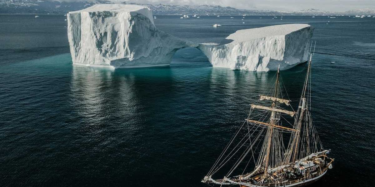 Sailing vessel navigating icebergs in Arctic waters