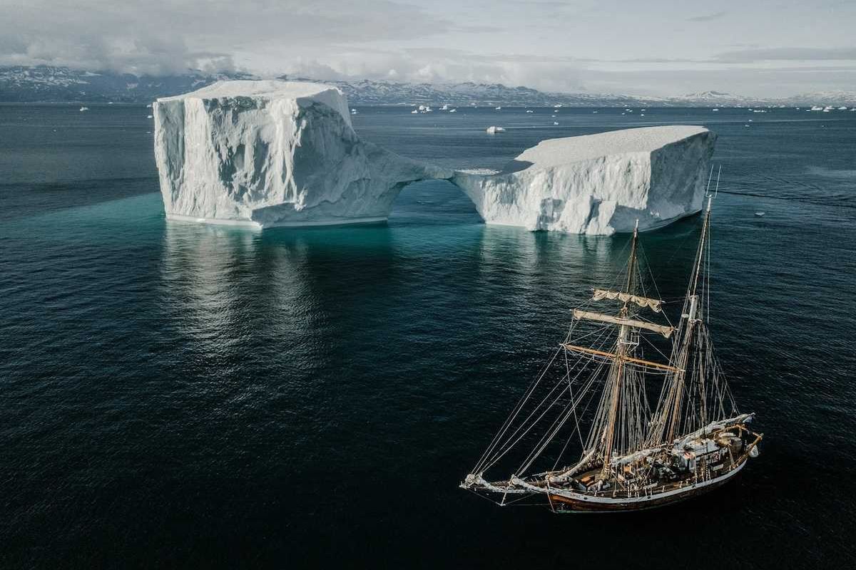 Sailing vessel navigating icebergs in Arctic waters