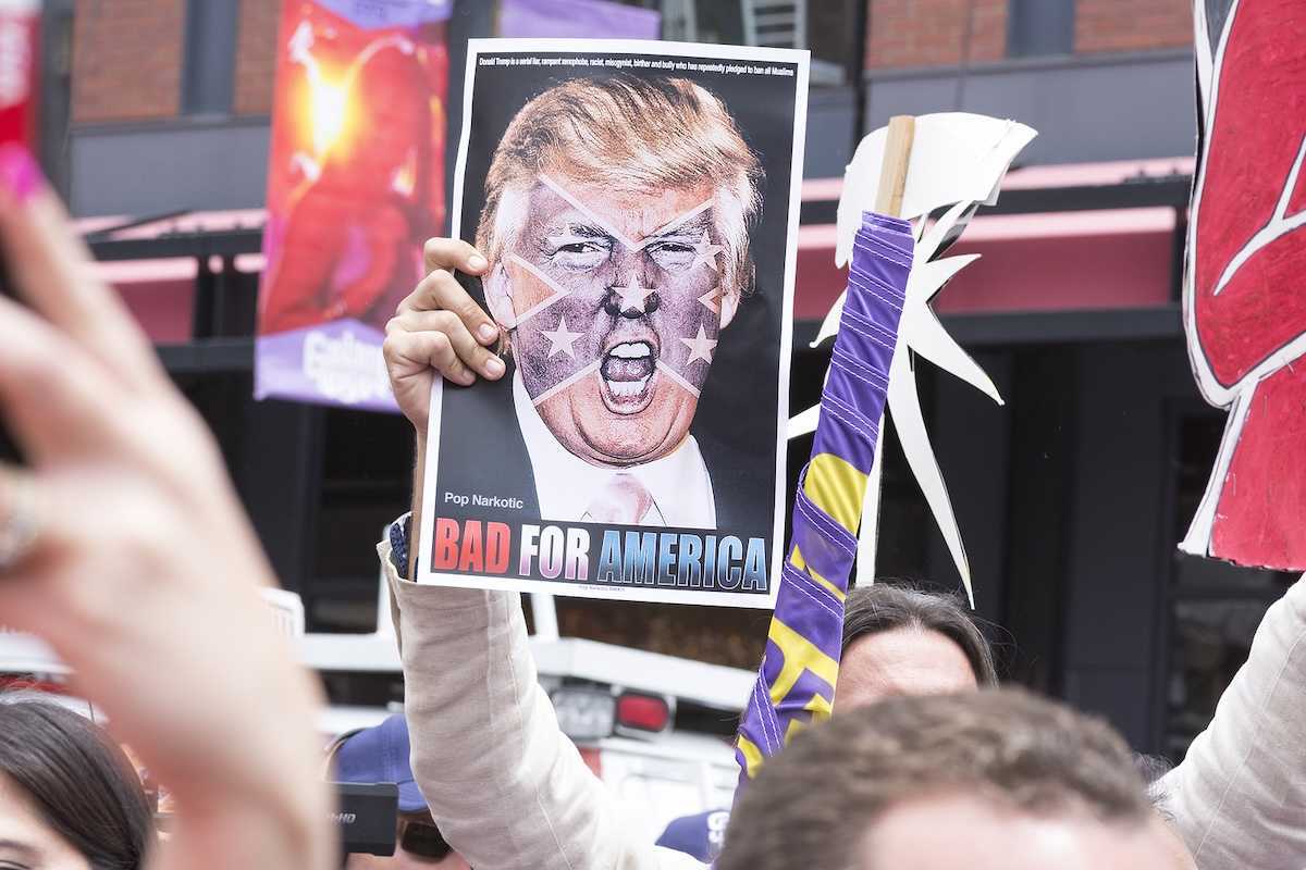 SAN DIEGO USA - MAY 27 2016: A protester holds a sign featuring an angry photo of Donald Trump and reading "Bad for America" at an anti-Trump protest outside a Trump rally in San Diego