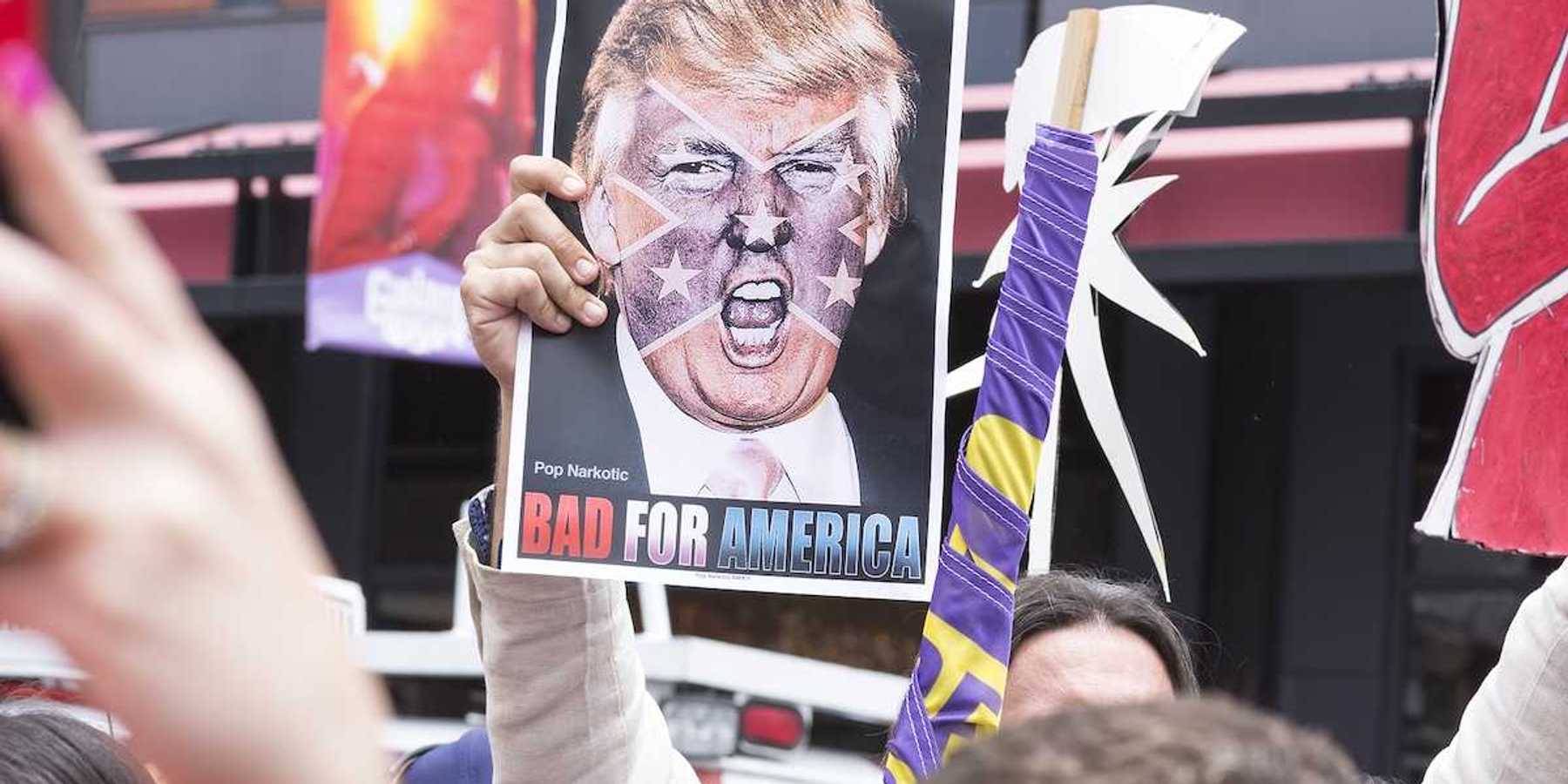 SAN DIEGO USA - MAY 27 2016: A protester holds a sign featuring an angry photo of Donald Trump and reading "Bad for America" at an anti-Trump protest outside a Trump rally in San Diego.