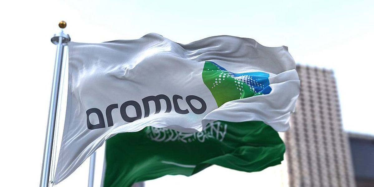 Saudi Aramco flag with a skyscraper in background.