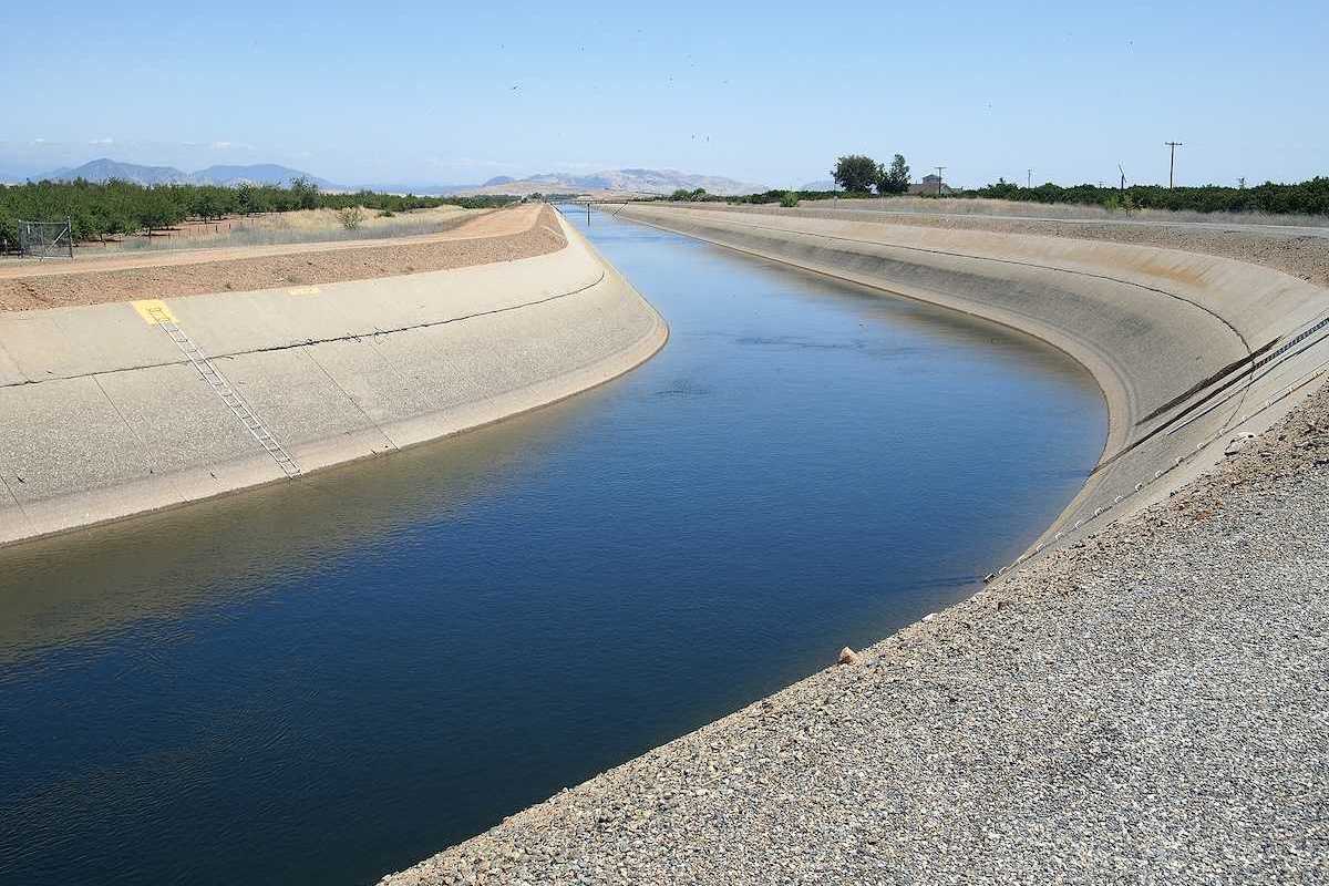 Save Download Preview Irrigation water flows in a canal near an orange grove.