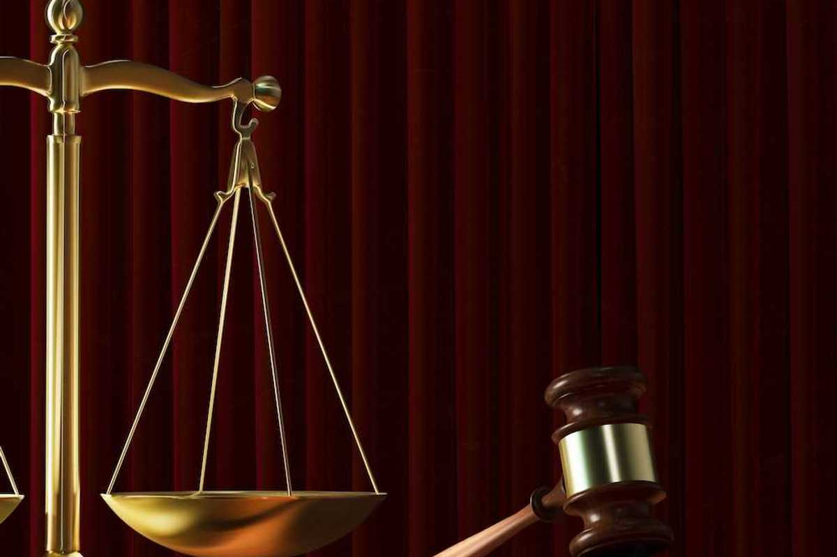 Scales of justice adjacent to a judges gavel signifying court ruling
