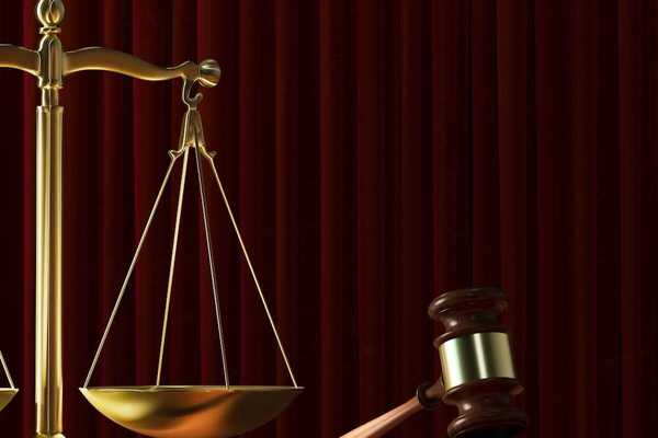 Scales of justice adjacent to a judges gavel signifying court ruling
