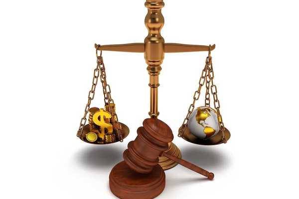 Scales of justice depicting wealth balanced against earth globe.