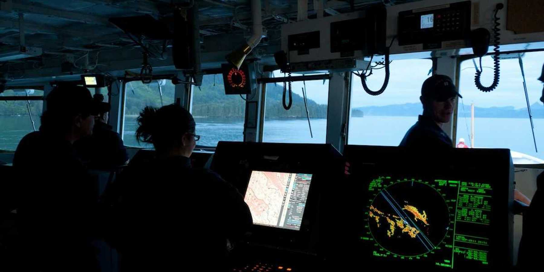 Scientific research vessel with 3 crew members surrounded by electronic instruments