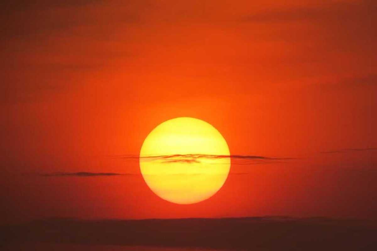 Setting sun at dusk against a red-orange sky
