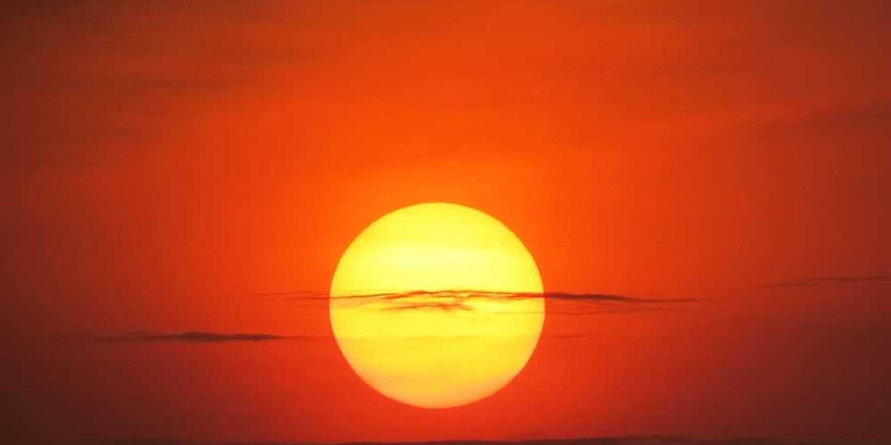 Setting sun at dusk against a red-orange sky