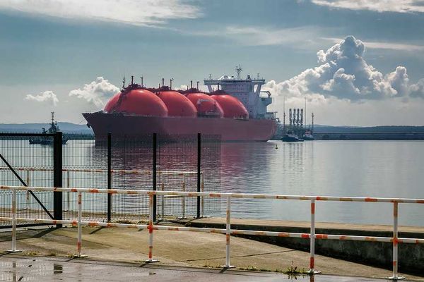 Ship and tugs are maneuvering at an LNG terminal