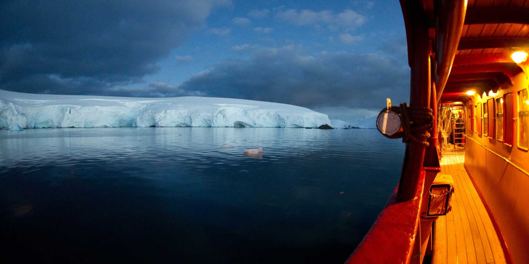 ship floating on ocean heading to ice burg