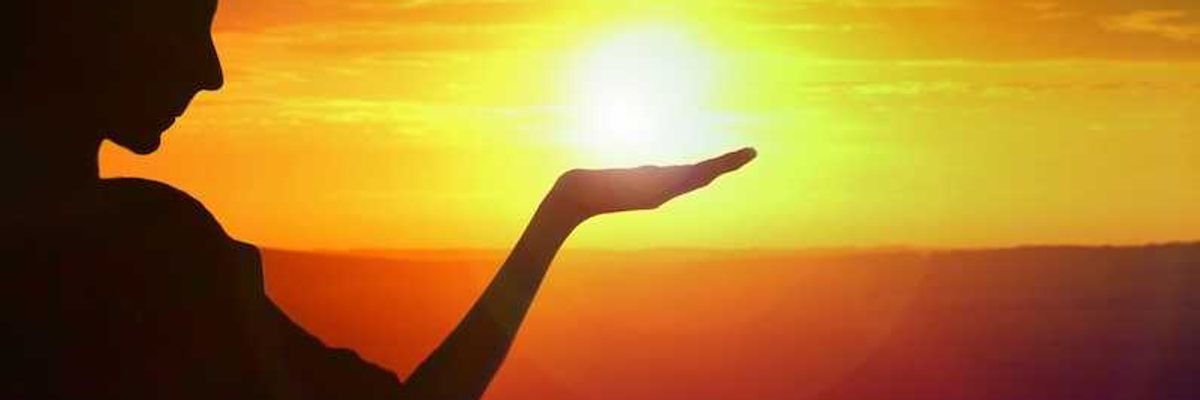 silhouette of a girl facing sunset, golden sky and water